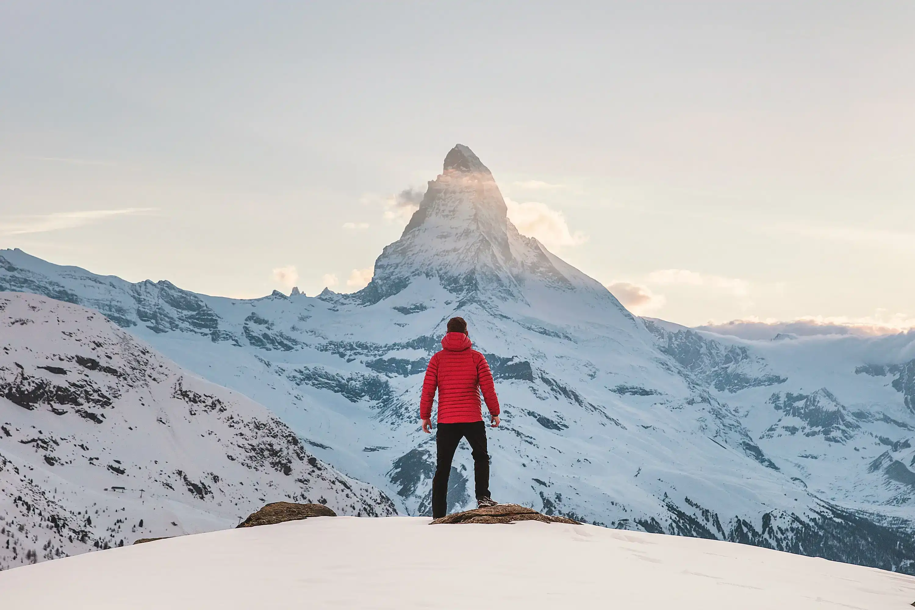 A person that climbed the mountain is very happy with hands in the air